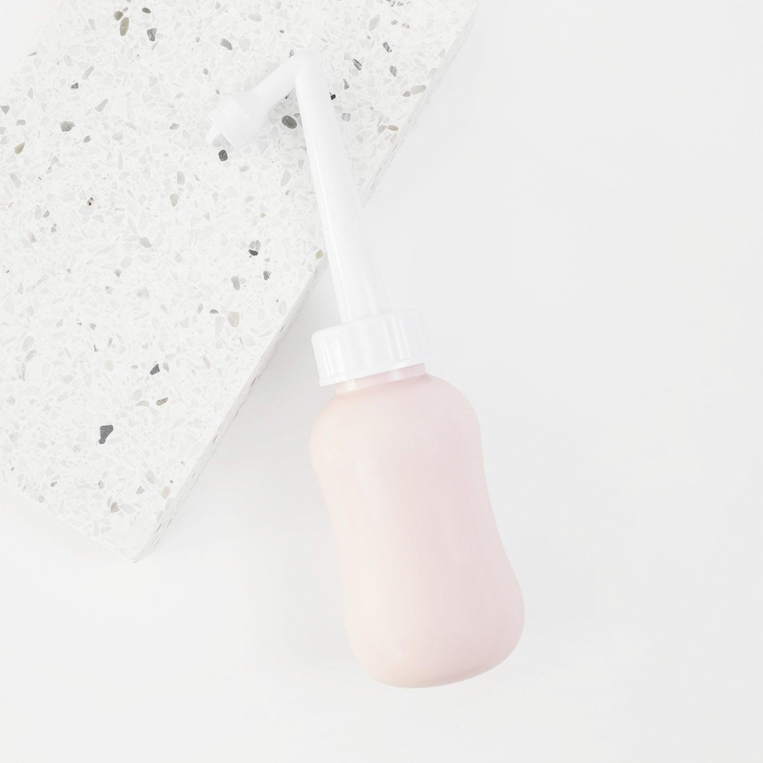 peri bottle for postpartum recovery laying on a terrazzo tile