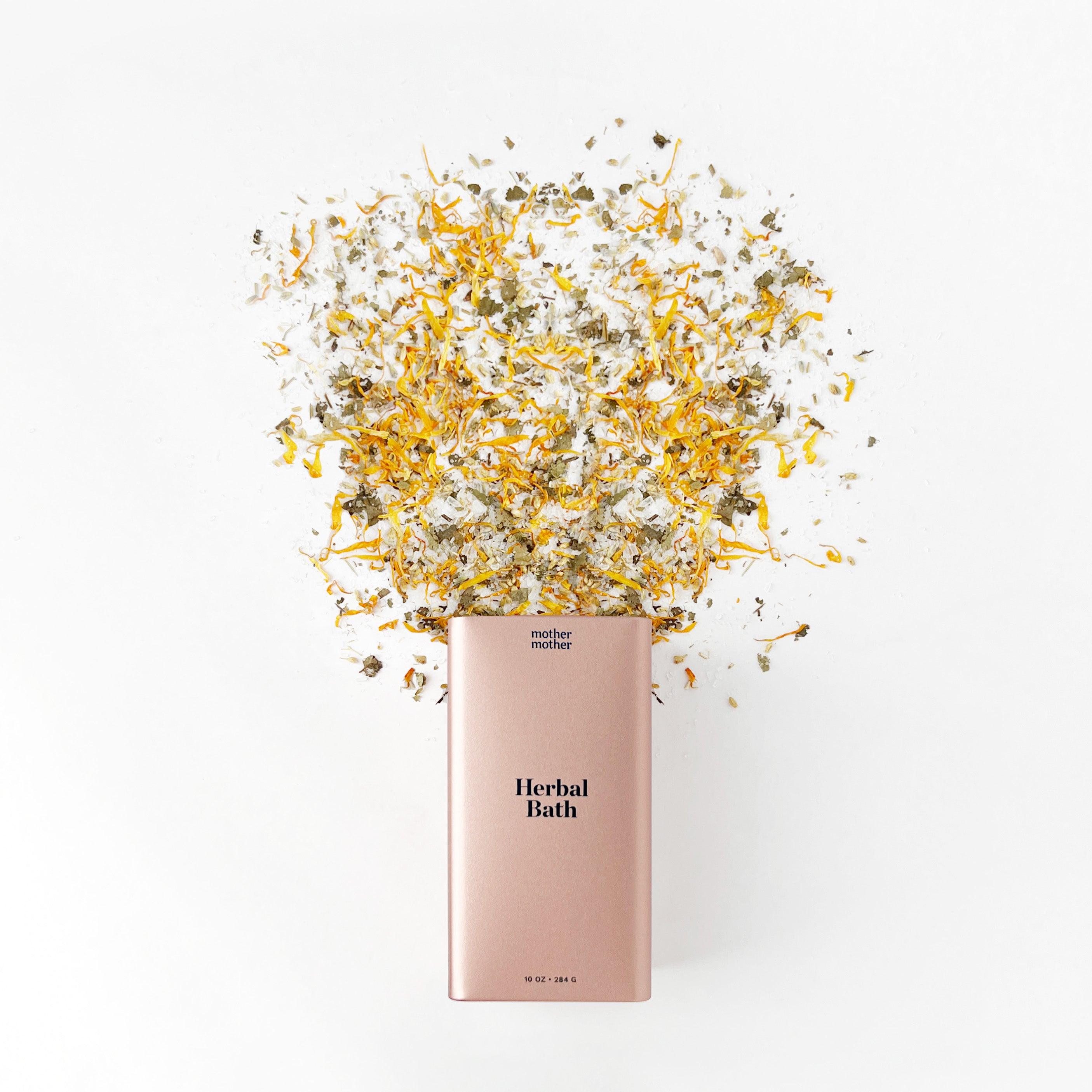 herbal bath pink tin with herbs spilling out on a white background