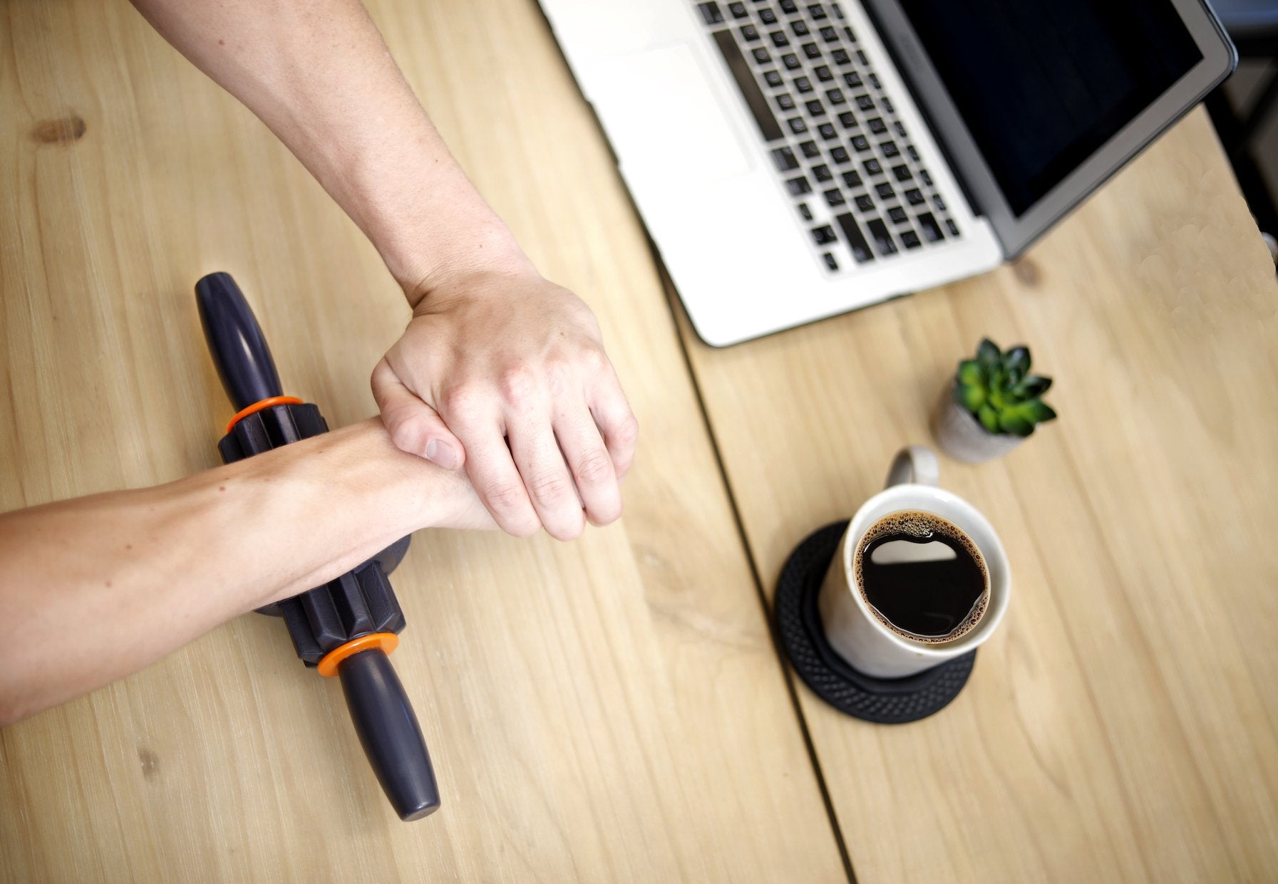 man using massage stick on wrist